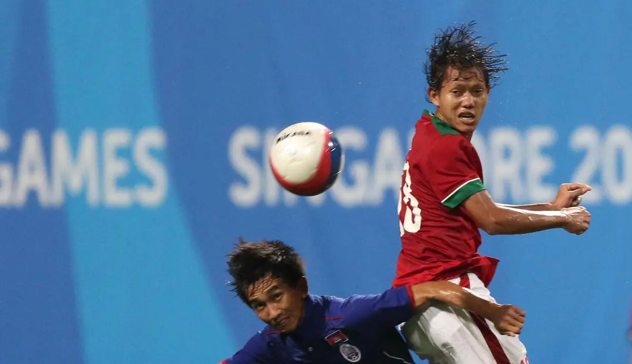 Pemain Indonesia U-23, Adam Alis Setyano, berebut bola dengan Kamboja U-23, Sopheng Keo.  (Bola.com/Arief Bagus)