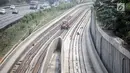Pekerja terihat di pembangunan proyek kereta api ringan (light rail transit/LRT) di kawasan Kampung Makasar, Jakarta, Kamis (26/7). Secara keseluruhan, proyek kereta ringan atau LRT Jakarta telah rampung sekitar 85 persen. (Liputan6.com/Faizal Fanani)
