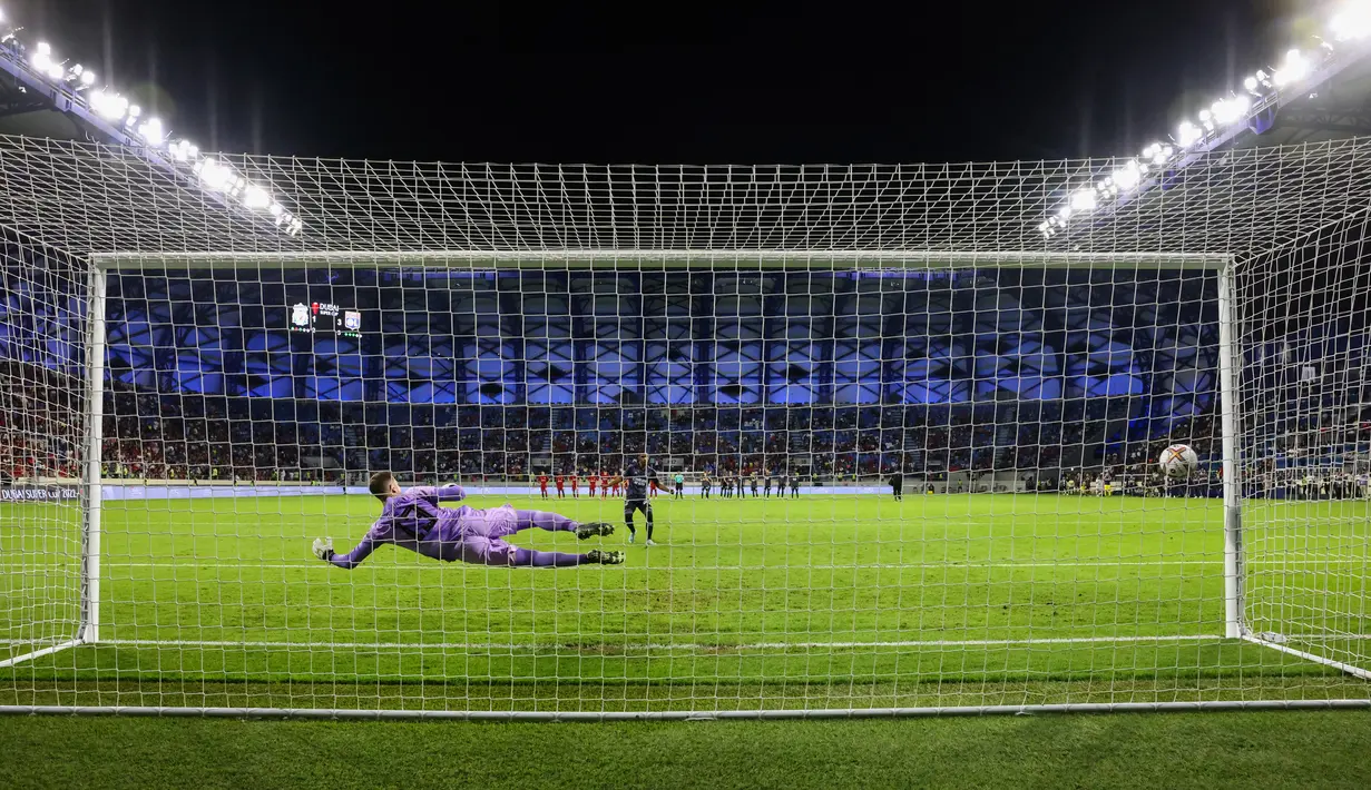 Penyerang Lyon, Tete mencetak gol penalti ke gawang Liverpool selama pertandingan Dubai Super Cup 2022 di Al Maktoum Stadium, Uni Emirat Arab, Minggu (11/12/2022). Lyon menang atas Liverpool 3-1. (AFP/Karim Sahib)
