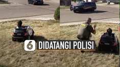 Ia yang tengah berada di balik kemudi mobil polisi mainan tampak kebingungan.