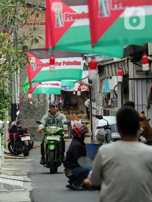 <p>Pemasangan spanduk dan bendera dilakukan oleh anak-anak muda yang tergabung dalam karang taruna. (Liputan6.com/Angga Yuniar)</p>