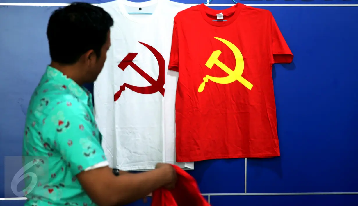 Petugas melihat barang bukti saat rilis penangkapan tersangka penjual kaus berlogo palu arit secara online di Bareskrim Polri, Jakarta, Jumat (30/12). Pelaku, HS, dianggap melanggar UU Nomor 27 Tahun 1999 tentang Keamanan Negara (Liputan6.com/Johan Tallo)