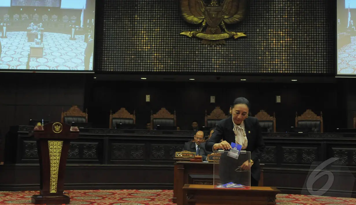 Hakim Konstitusi, Maria Farida Indrati saat memasukkan kertas suara ke dalam kotak suara pemilihan Ketua dan Wakil Ketua MK di Gedung MK, Jakarta, Senin (12/1/2015). (Liputan6.com/Herman zakharia)