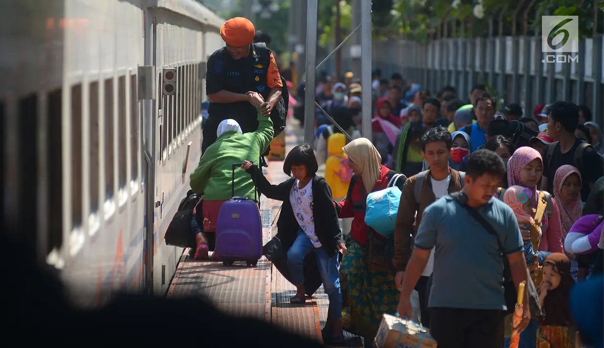 Petugas membantu penumpang saat tiba di Stasiun Senen, Jakarta, Senin (18/6). Belum terjadi lonjakan pemudik pada arus balik tiga hari setelah Lebaran. (Merdeka.com/Imam Buhori)