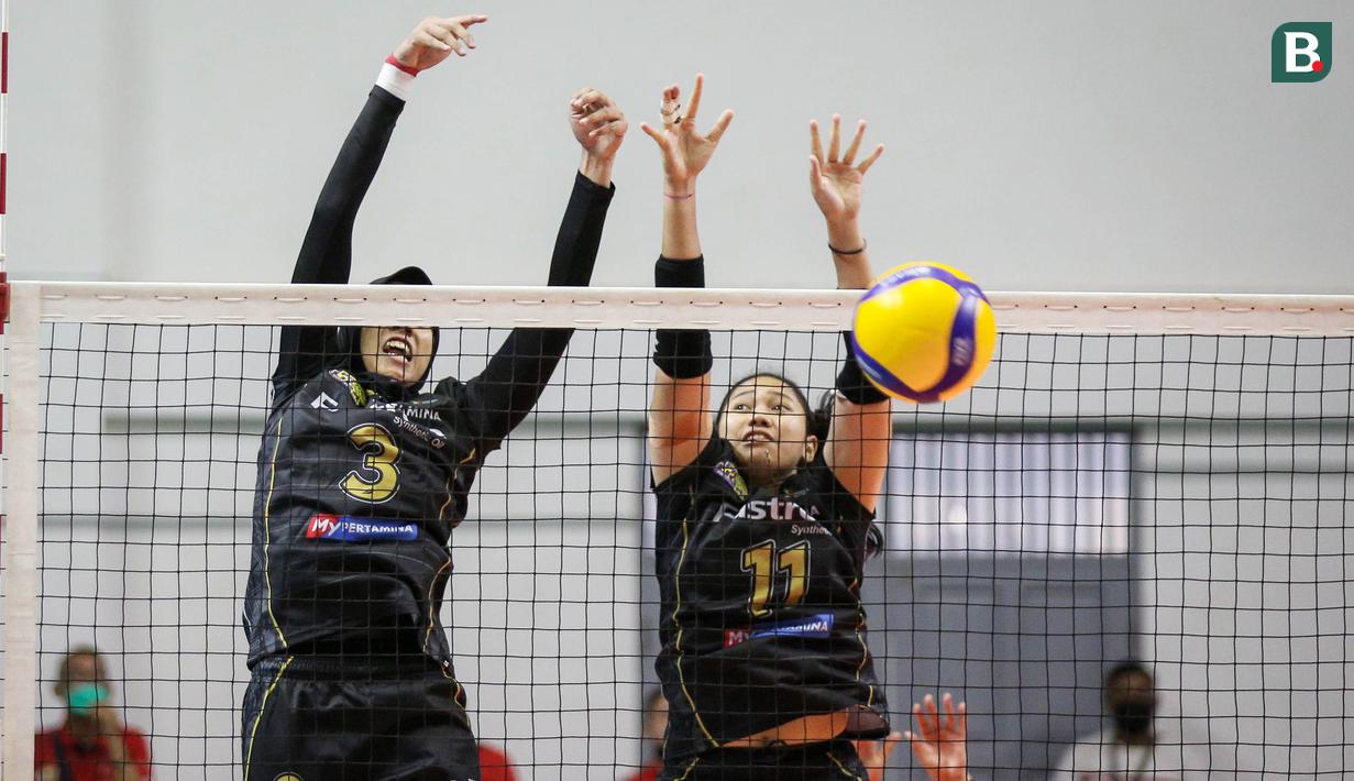 Pemain Jakarta Pertamina Fastron, Megawati Hangestri Pertiwi (kiri) dan Myrasuci Indriani berusaha menahan bola saat leg kedua final four PLN Mobile Proliga 2022 melawan Gresik Petrokimia Pupuk Indonesia di Padepokan Voli Jenderal Polisi Kunarto, Jumat (18/03/2022). (Bola.com/Bagaskara Lazuardi)