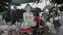 Para pekerja memoles patung Buddha di desa Sagyin, Madaya, Myanmar pada 22 Desember 2018. Desa Zagyin atau biasa disebut Marble ini merupakan tempat terbesar di dunia dalam memproduksi patung Buddha dalam segala ukuran. (YE AUNG THU / AFP)