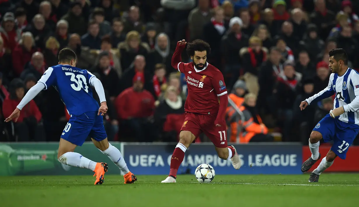 Gelandang Liverpool Mohamed Salah berusaha mengendalikan bola dengan kawalan pemain FC Porto pada leg kedua babak 16 besar Liga Champions di Stadion Anfield, Selasa (6/3). Liverpool melaju ke perempat final dengan bermain imbang tanpa gol (PAUL ELLIS/AFP)