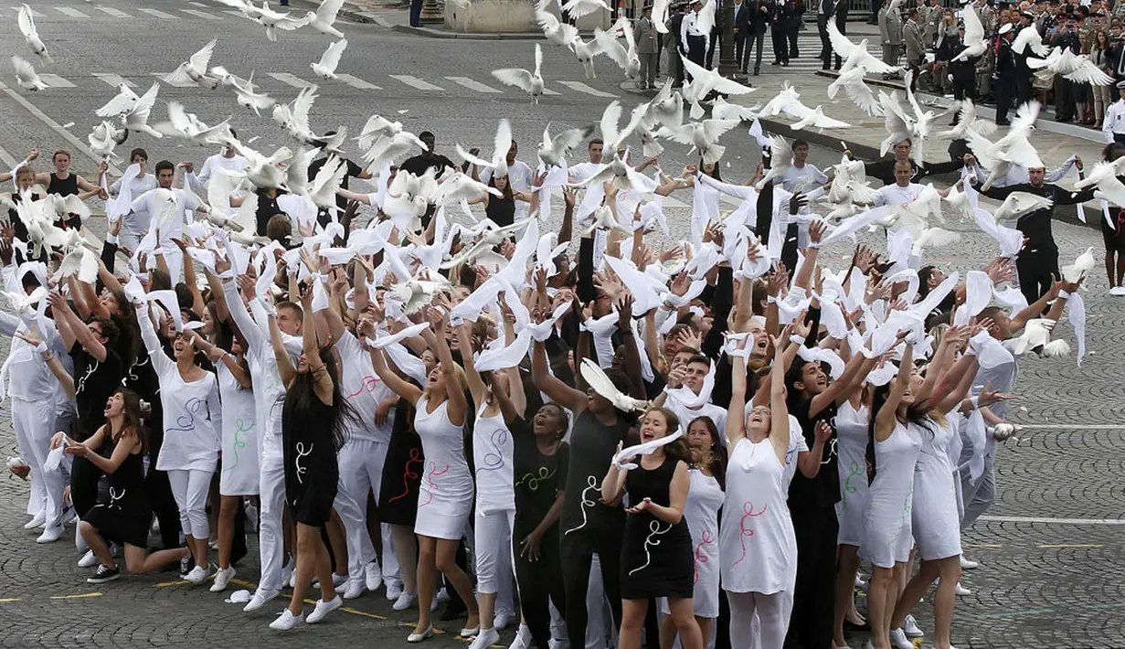 Di akhir upacara peringatan Bastile Days 2014 di jalan Champs Elysees, Paris, (14/7/2014), sejumlah pemuda melepaskan merpati. Bastile Days merupakan nama lain untuk Hari Nasional Perancis yang dirayakan setiap 14 Juli. (REUTERS/Benoit Tessier)