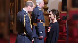 Victoria Beckham berbincang dengan Pangeran William sebelum menerima gelar Order of the British Empire (OBE) di Istana Buckingham di London, Inggris (19/4). Wanita 43 tahun itu ditemani sang suami saat menerima penghargaan tersebut. (Yui Mok / PA via AP)