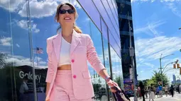 Pevita Pearce tersenyum saat berjalan mengenakan blazer dan celana pendek berwarna pink dengan dalaman model crop top putih yang memperlihatkan perut ratanya serta sepatu putih. Pevita terlihat percaya diri dengan outfit yang dikenakannya. (Instagaram/pevpearce)