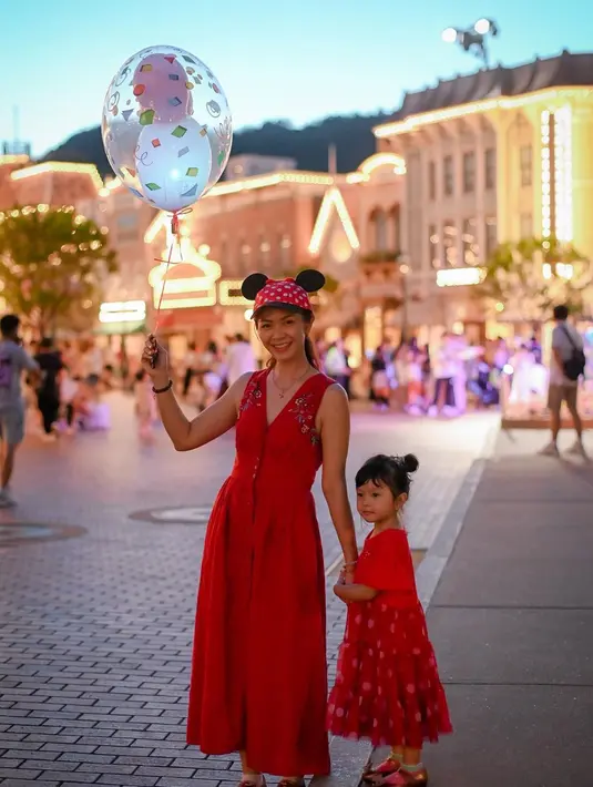 Memilih liburan di musim panas membuat siang hari terasa sangat melelahkan, namun semua sirna dengan keindahan malam hari Disneyland. Lampu-lampu yang menyorot membuat suasana bagaikan negeri dongeng. Bersama sang anak, Tyara tampil bak putri disney yang membawa balon. (Liputan6.com/IG/@tyararenata)