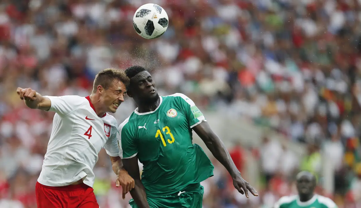 Bek Polandia, Thiago Cionek, duel udara dengan gelandang Senegal, Alfred Ndiaye, pada laga Piala Dunia di Stadion Spartak, Selasa (19/6/2018). Senegal menang 2-1 atas Polandia. (AP/Darko Vojinovic)