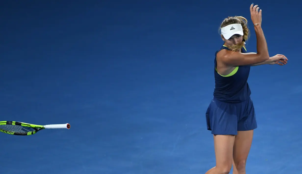 Petenis Denmark, Caroline Wozniacki melempar raketnya ketika melawan petenis Belanda, Kiki Bertend di babak ketiga Australia Terbuka 2018, Jumat (19/1). Wozniacki kecewa dengan keputusan wasit yang membuatnya kehilangan satu poin. (WILLIAM WEST/AFP)
