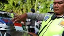 Polisi menempelkan stiker bendera Indonesia dan Arab Saudi selama persiapan menyambut Raja Arab Saudi Salman bin Abdulaziz,Nusa Dua, Bali (2/3). Raja Salman akan berlibur di Bali tanggal 4 sampai 9 Maret. (AFP Photo / Sonny Tumbelaka)