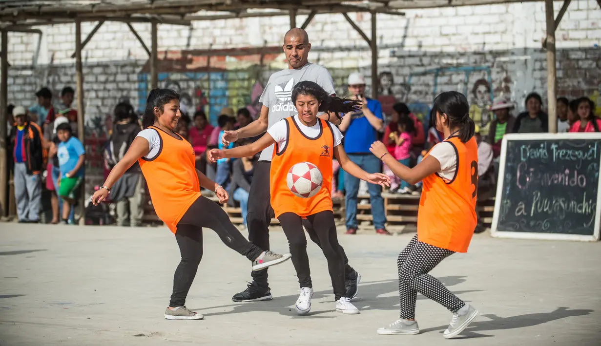 Sejumlah anak berebut bola saat bermain bersama David Trezeguet di komunitas San Pablo Mirador, Peru (13/7). (AFP Photo/Ernesto Benavides)