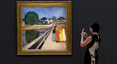 Pengunjung mengabadikan lukisan karya seniman Norwegia, Edvard Munch “Girls on the Bridge” di New York, 4 November 2016. Dalam sebuah lelang pada 14 November, lukisan dari 1902 itu terjual dengan harga USD54,5 juta (setara Rp727 M). (Timothy A. CLARY/AFP)