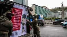 Petugas Satpol PP memasang spanduk mini untuk memberikan imbauan sekaligus sosialisasi kepada masyarakat guna mencegah penularan Covid-19 di Bundaran HI, Jakarta, Kamis (19/3/2020). (Liputan6.com/Faizal Fanani)