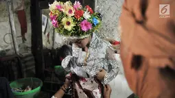 Gadis dirias oleh keluarga sebelum mengikuti Upacara Adat Ngarot di Desa Lelea, Kabupaten Indramayu, Jawa Barat, Rabu (19/12). Para gadis didandani mengenakan setelan kebaya dan kain batik dipadu dengan selendang. (Merdeka.com/Iqbal Nugroho)