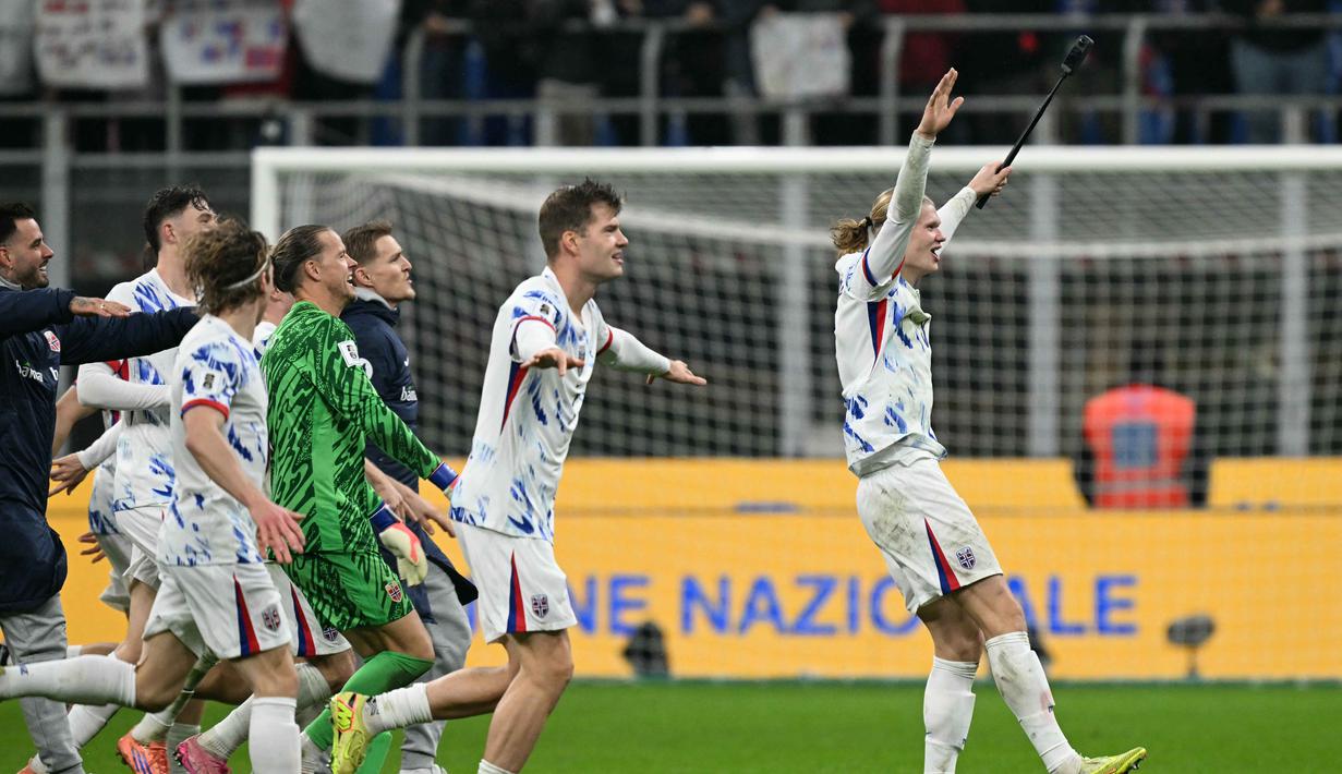 Haaland juga mencatatkan namanya sebagai pencetak gol terbanyak (top skor) Grup I Kualifikasi Piala Dunia 2026 zona Eropa. Tampak dalam foto, kapten Timnas Norwegia, Erling Braut Haaland merayakan kemenangan bersama rekan-rekannya setelah Norwegia mengalahkan Italia dalam pertandingan kualifikasi Piala Dunia 2026 zona Eropa di Stadion San Siro, Milan, pada 16 November 2025. (Stefano RELLANDINI/AFP)