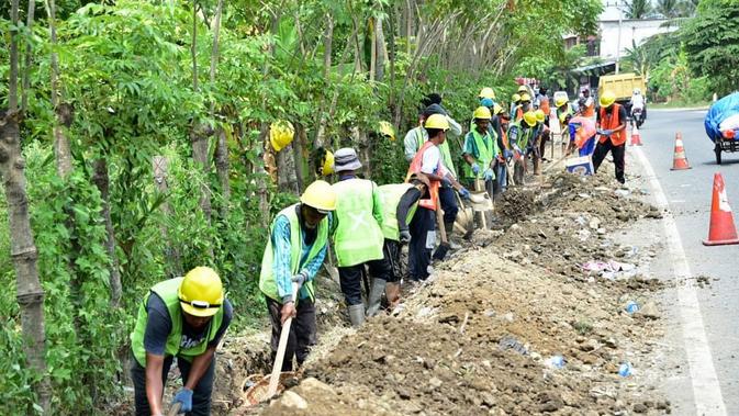 Pekerjaan revitalisasi saluran drainase jalan nasional sepanjang 5.000 Km yang termasuk dalam cakupan program Padat Karya Tunai (PKT). (Dok Kementerian PUPR)