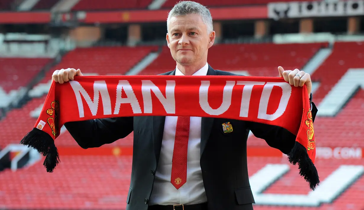 Ole Gunnar Solskjaer menunjukkan syal Manchester United saat konferensi pers di Stadion Old Trafford, Inggris, (28/3). Pria asal Norwegia tersebut mulai duduk di kursi manajer MU pada 19 Desember 2018, menggantikan peran Jose Mourinho. (AP Photo/Rui Vieira)