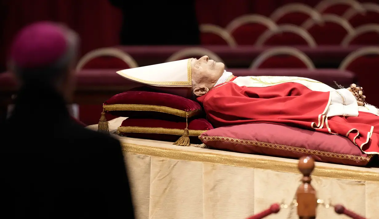 Jenazah mendiang Paus Emeritus Benediktus XVI disemayamkan di Basilika Santo Petrus, Vatikan, Senin (2/1/2023). Benediktus XVI, teolog Jerman yang akan dikenang sebagai paus pertama dalam 600 tahun yang mengundurkan diri, telah meninggal pada 31 Desember 2022 di usia 95 tahun. (AP Photo/Andrew Medichini)