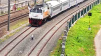 Kereta api melintas di jalur dwiganda atau double-double track (DDT) di kawasan Cipinang, Jakarta, Jumat (12/4). DDT segmen Jatinegara-Cakung mulai digunakan pada hari ini. (Liputan6.com/Herman Zakharia)