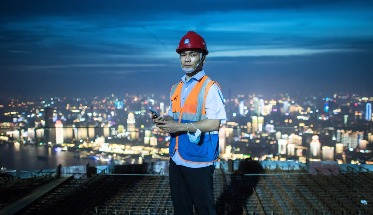 Seorang pekerja konstruksi bekerja di ketinggian sekitar 500 meter di lokasi pembangunan sebuah bangunan bertingkat tinggi di Wuhan, Provinsi Hubei, China tengah (11/8/2020). Para pekerja konstruksi harus menghadapi ketinggian dan panasnya udara musim panas. (Xinhua/Xiao Yijiu)