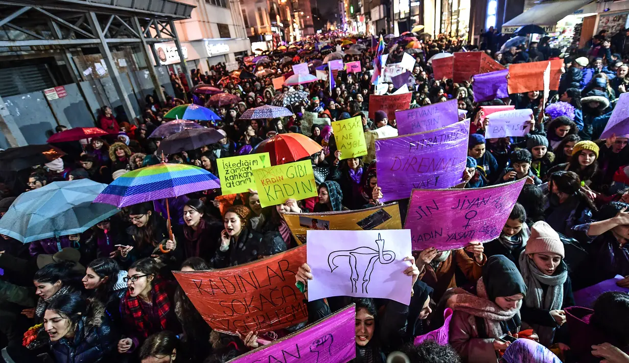 Wanita memegang spanduk bertuliskan "pemberontakan di jalan" saat memperingati Women's Day atau Hari Perempuan Internasional di Jalan Istiklal, Istanbul, Turki, Kamis (8/3). (OZAN KOSE/AFP)