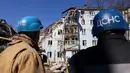 Tim penyelamat bekerja di gedung tempat tinggal berlantai lima yang hancur setelah serangan rudal di tengah invasi Rusia ke Ukraina di Zaporizhzhia pada 2 Maret 2023. Di antara mereka yang selamat adalah seorang pria berusia 30 tahun yang menurut petugas penyelamat terjebak di bawah lempeng beton akibat serangan rudal. (AFP/Katerina Klochko)