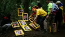 Pengunjuk rasa menjejerkan potret orang-orang yang dipenjara dan diasingkan karena mendukung presiden terguling Catalonia, Carles Puigdemont setelah mereka membawanya ke Gunung Montserrat, Spanyol (28/4). (AFP/Pau Barrena)