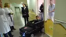Souvail (2) mengendarai mobil mainan listrik menuju ruang operasi di Rumah Sakit Valenciennes, Prancis, Jumat (2/2). Rumah sakit ini memiliki tiga mobil mainan yang salah satunya sumbangan dari Valenciennes Football Club. (FRANCOIS LO PRESTI/AFP)