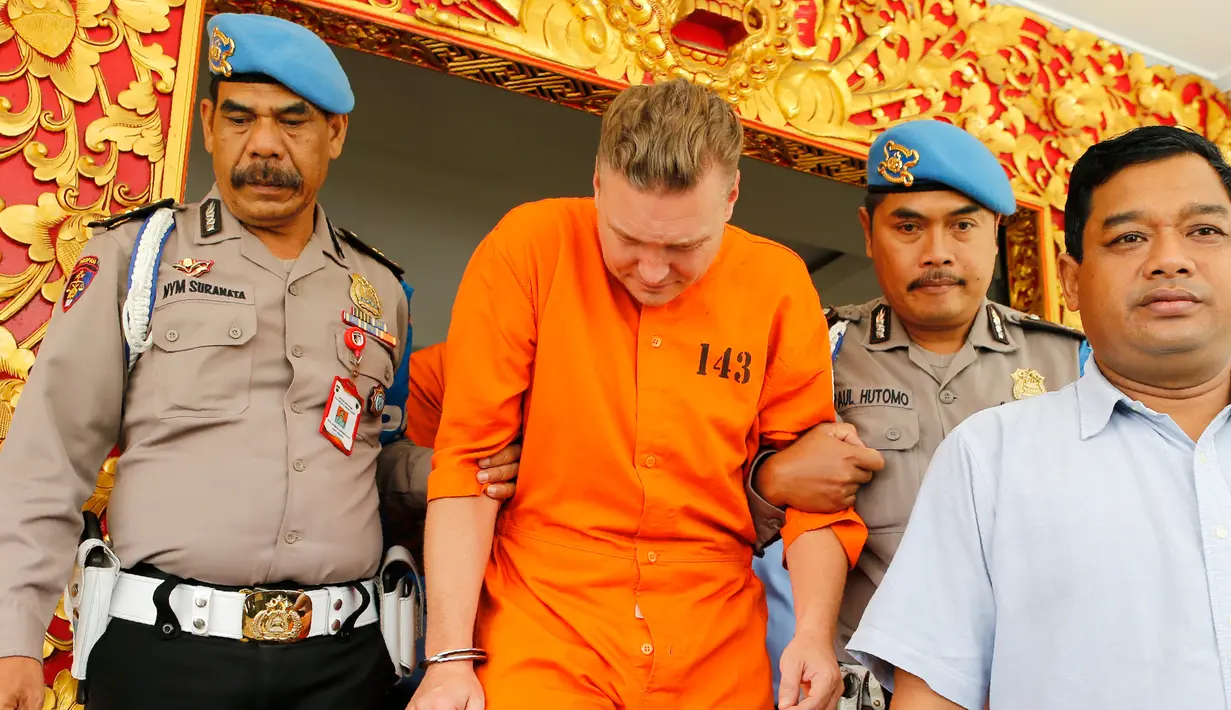 Polisi mengawal tersangka kasus narkoba asal Australia, David van Iersel, menuju lokasi konferensi pers di Mapolresta Denpasar, Bali, Selasa (23/7/2019). David ditangkap bersama rekannya, Wiliam Cabantog, di sebuah tempat hiburan di Badung, Bali, Jumat, 19 Juli 2019. (AP Photo/Firdia Lisnawati)