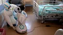 Wakil kepala unit perawatan intensif Flavio Tangian, menyiapkan robot di rumah sakit 'Ospedale di Circolo', di Varese, Italia, 8 April 2020. Sebanyak enam unit robot yang berjalan di atas roda ini membantu kinerja staf medis dalam merawat pasien virus corona Covid-19. (AP/Luca Bruno)