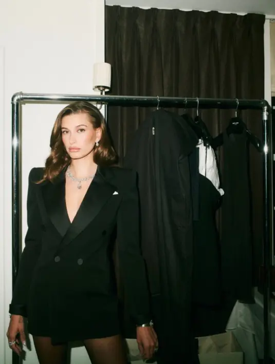 Hailey Bieber tampil mengenakan blazer hitam oversize dari YSL, ia pun tampil pantsless. Melengkapi tampilan dengan perhiasan mewah. [@ysl]