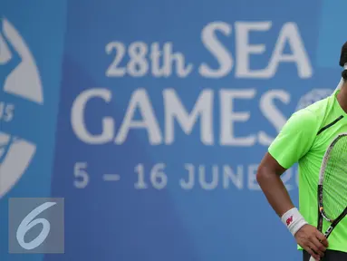 Petenis Indonesia, Christopher Rungkat tertunduk usai dikalahkan D Udomchoke (Thailand) di nomor beregu putra Sea Games 2015 di Kallang Tenis Centre, Singapura, Selasa (9/6/2015). Christopher Rungkat kalah 0-6, 4-6. (Liputan6.com/Helmi Fithriansyah)