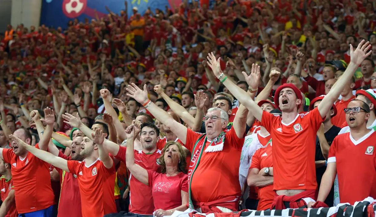 Suporter Wales meneriakkan yel-yel saat Wales mengalahkan Rusia 3-0 pada laga terakhir Grup B Piala Eropa 2016 di Stadion Municipal, Toulouse, Selasa (21/6/2016) dini hari WIB. (AFP/Remy Gabalda)