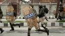 Pasukan tentara membawa peralatan lengkap berusaha membubarkan ratusan pengunjuk rasa usai salat Idul Fitri di Srinagar, India (26/6). (AP Photo / Mukhtar Khan)