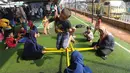 Kebahagiaan anak-anak saat bermain rangku alu di Taman Bermain Masyarakat (TBM) Kolong Ciputat, Tangsel, Banten, Minggu (22/7). (Merdeka.com/Arie Basuki)
