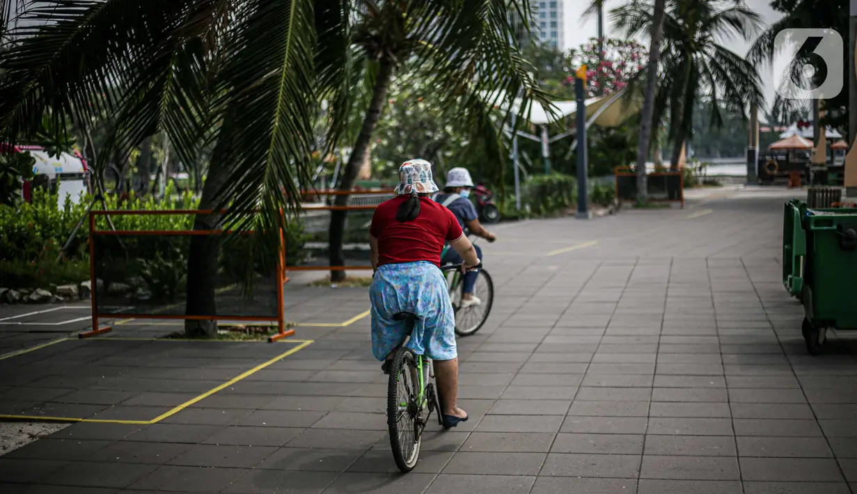 Pengunjung bersepeda di kawasan Taman Impian Jaya Ancol, Jakarta, Sabtu (11/10/2021). Kawasan rekreasi Taman Impian Jaya Ancol menjadi salah satu dari 20 destinasi wisata yang direkomendasikan beroperasi kembali dalam uji coba pembukaan kawasan rekreasi. (Liputan6.com/Faizal Fanani)