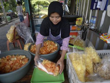 Pekerja menimbang keripik singkong rumahan di Kampung Kopi, Gunung Sindur, Bogor, Jawa Barat, Selasa (8/9/2020). Camilan yang dijual dengan harga Rp 8 ribu hingga Rp 50 ribu tergantung rasa tersebut banyak diminati warga di masa pandemi. (merdeka.com/Dwi Narwoko)
