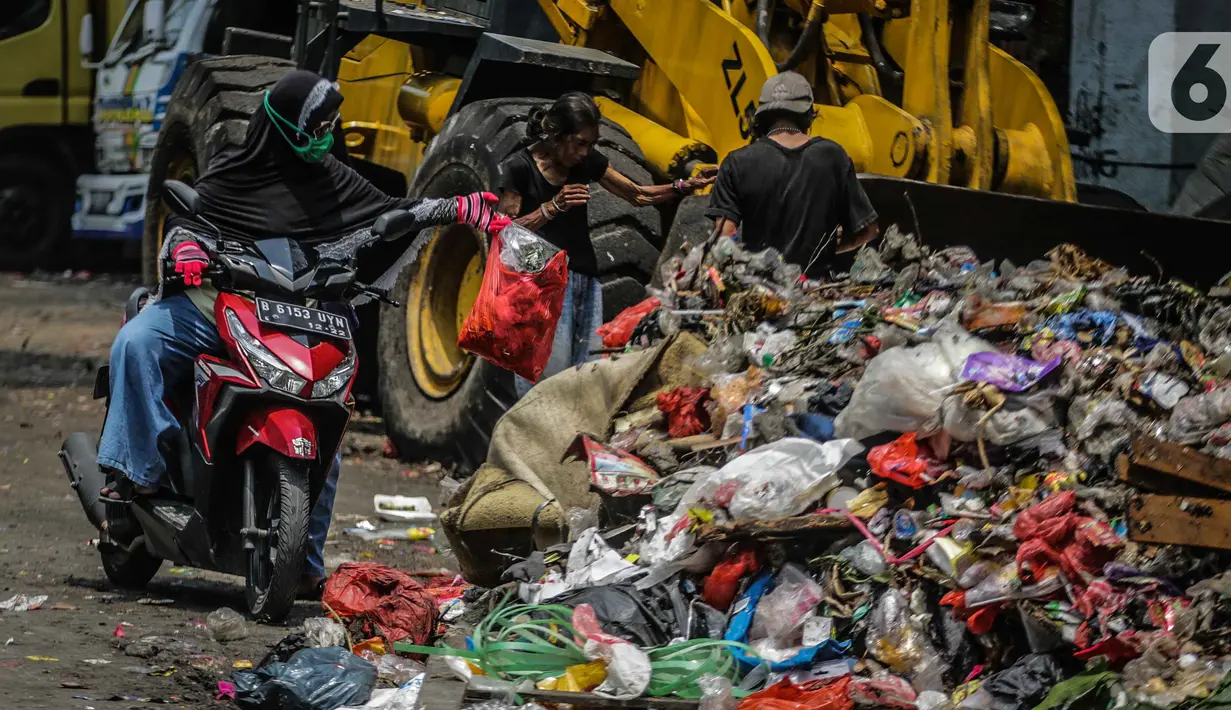 Pengendara motor membuang sampah di kolong tol Wiyoto Wiyono, Tanjung Priok, Jakarta, Selasa (5/11/2019). Sampah yang menumpuk  berasal dari sampah rumah tangga warga sekitar yang tidak memiliki tempat pembuangan sampah sementara.  (Liputan6.com/Faizal Fanani)