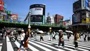 Sejumlah orang menggunakan payung dan topi untuk melindungi dirinya dari sinar matahari selama gelombang panas saat melintasi jalan di distrik Shinjuku Tokyo, Minggu (4/8/2019). Setelah menyerang beberapa wilayah di Eropa, suhu tinggi juga terjadi di Jepang. (Charly TRIBALLEAU / AFP)