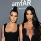 Kim Kardashian (kanan) dan Kourtney Kardashian berpose saat menghadiri Gala amfAR New York AIDS 2019 di Cipriani Wall Street, Rabu (6/2). (Photo by Evan Agostini/Invision/AP)