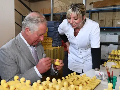 Pangeran Charles melukis sabun wangi  berbentuk bebek selama kunjungannya ke pabrik laboratorium Parfumerie Fragonard di Eze, dekat Nice, Prancis selatan, (7/5). (AFP Photo/Pool/Boris Horvat)