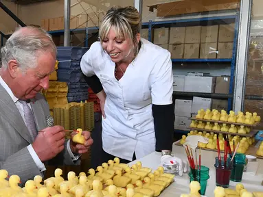 Pangeran Charles melukis sabun wangi  berbentuk bebek selama kunjungannya ke pabrik laboratorium Parfumerie Fragonard di Eze, dekat Nice, Prancis selatan, (7/5). (AFP Photo/Pool/Boris Horvat)