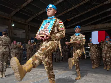Foto yang diambil dan dirilis oleh Pasukan Sementara Perserikatan Bangsa-Bangsa di Lebanon (UNIFIL), menunjukkan rekan-rekan membawa peti jenazah dan foto seorang Tentara Nasional Indonesia, Kopral Rico Pramudia, saat upacara penghormatan di Bandara Internasional Lebanon, Beirut, pada 26 April 2026. Kontingen Pasukan Sementara Perserikatan Bangsa-Bangsa di Lebanon (UNIFIL) menggelar upacara penghormatan untuk Prajurit TNI Kopral Rico Pramudia. (Haidar Fahs/UNIFIL/AFP)