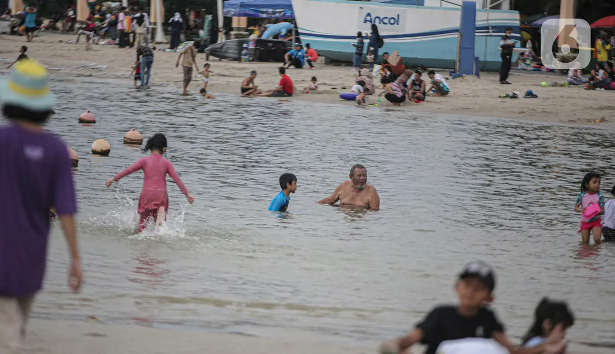Pengujung berwisata di Pantai Ancol, Jakarta, Rabu (28/12/2022). Isu cuaca yang kurang bersahabat pada hari ini, tidak menyurutkan keinginan warga menghabiskan libur untuk berwisata di kawasan wisata Ancol. (Liputan6.com/Faizal Fanani)