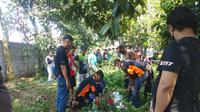 Petugas Unit Identifikasi Polres Metro Bekasi Kota mengevakuasi jasad pemuda yang diduga bunuh diri di sebuah pohon, Sabtu (14/1/2023). (Dok. Liputan6.com/Bam Sinulingga)