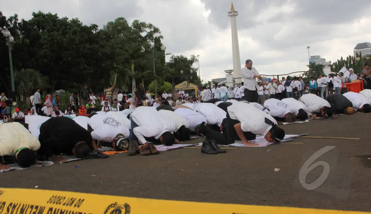 Massa dari Aliansi TKI Menggugat melakukan aksi unjuk rasa dengan cara salat di depan Istana Negara, Jakarta, (7/4/2015). Massa menuntut Presiden Jokowi mencabut moratorium larangan pengiriman TKI ke Timur Tengah. (Liputan6.com/Helmi Afandi)